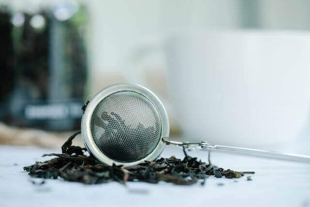 Loose black tea leaves in a tea strainer